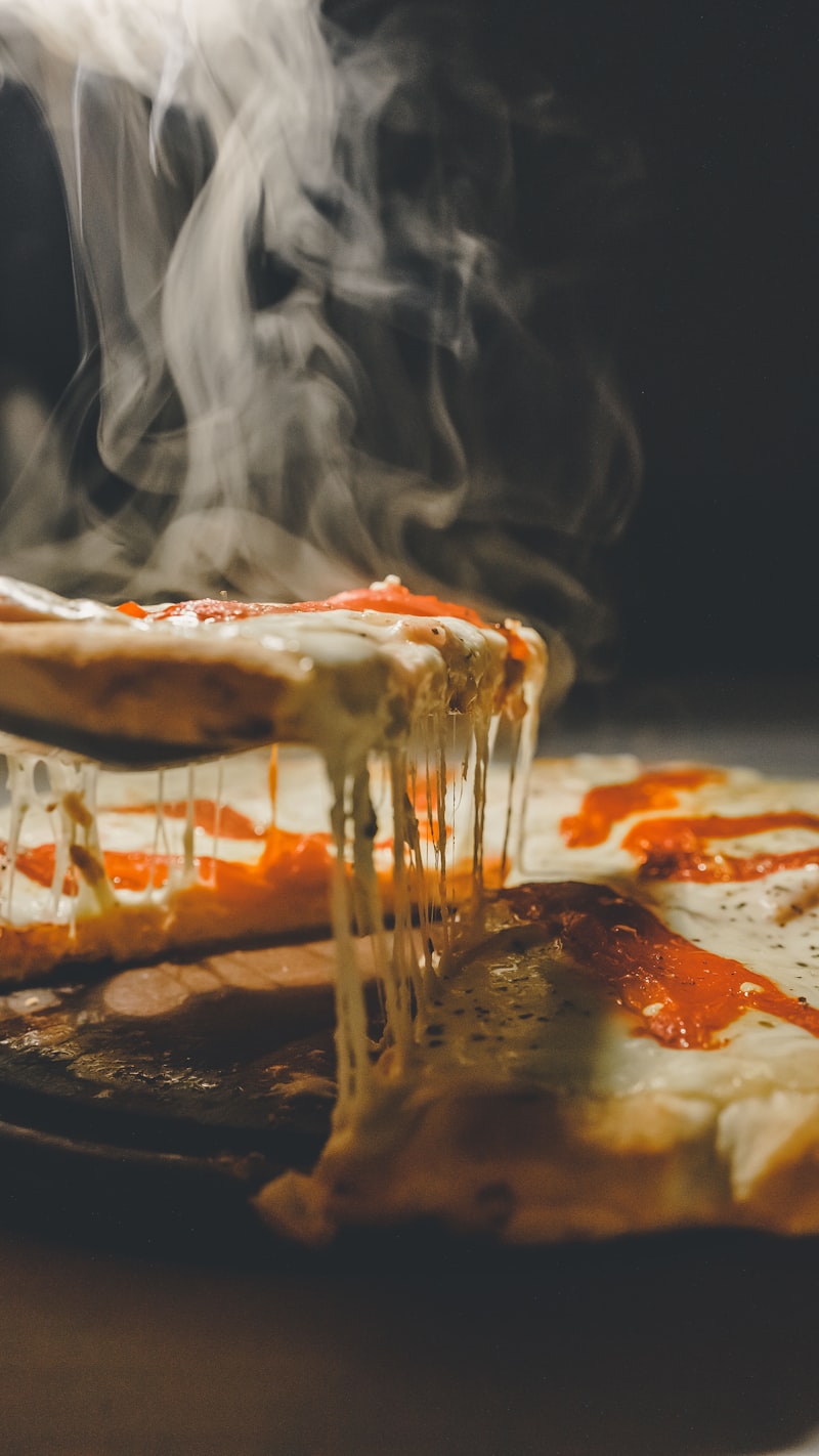 Pizzaiolo travaillant la pâte à la main devant le four à bois
